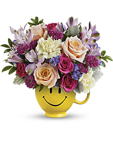 Cheerful smile face flower arrangement in a smiling yellow pot, bright pink and purple flowers.
